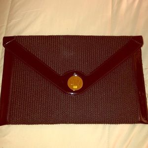 Black straw/patten-leather clutch with strap.